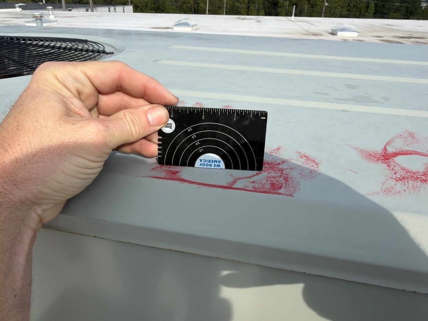 Measuring a hail impact on a TPO roof.